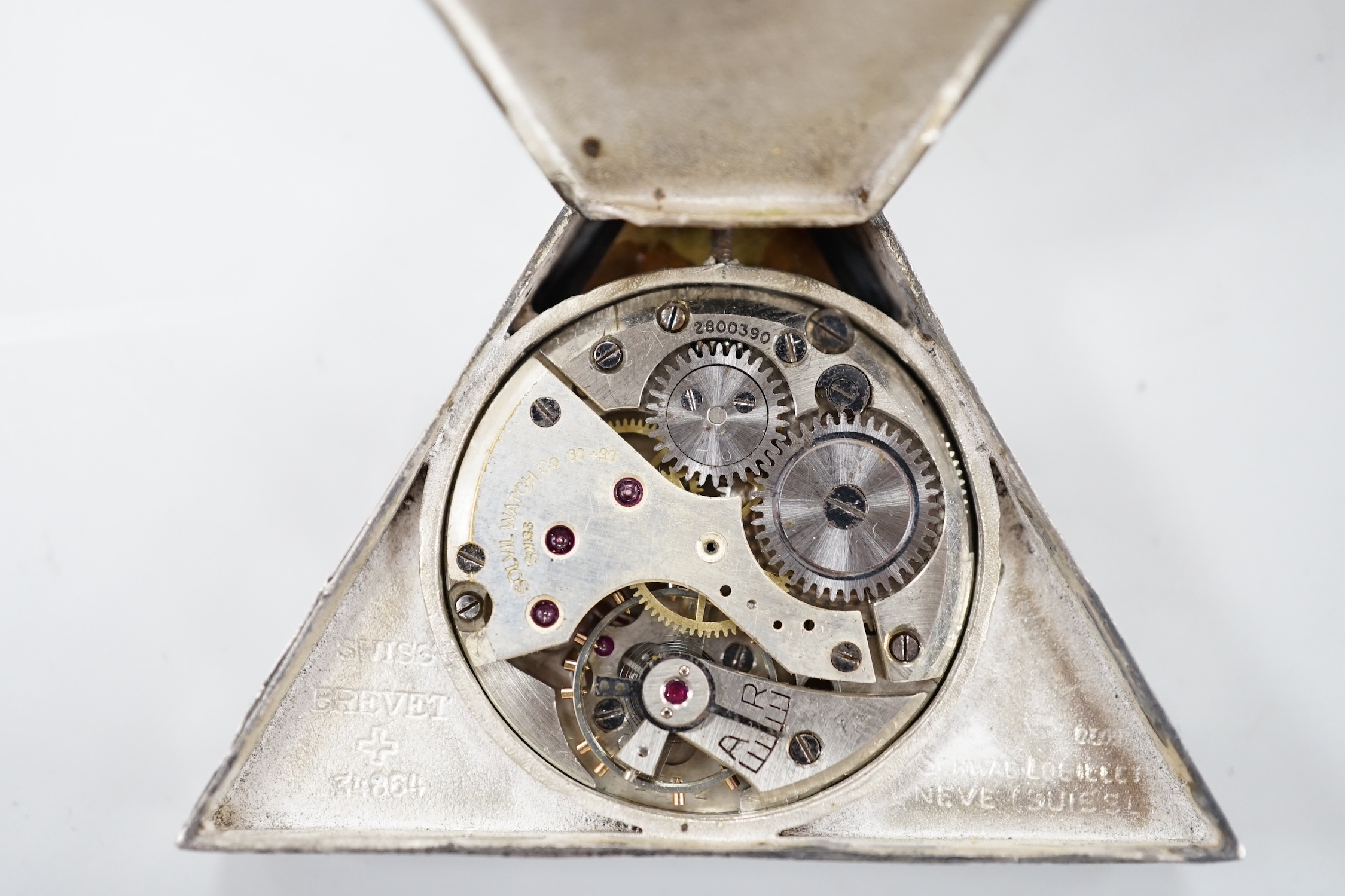 A 1920's Swiss 800 standard white metal triangular masonic pocket watch, by the Solvil Watch Co. set with cabochon garnet, the mother of pearl dial decorated with masonic symbols, width, 51mm.